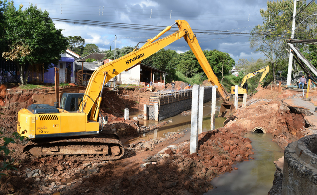 Duas máquinas amarelas trabalhando no arroio
