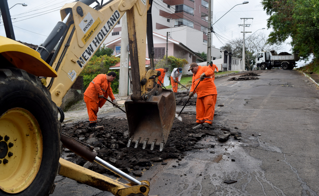 Uma máquina escava o asfalto em uma rua
