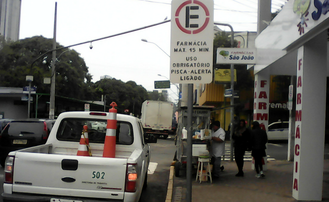 Placa com funco branco com a indicação de tempo máximo de 15 minutos para estacionar no local