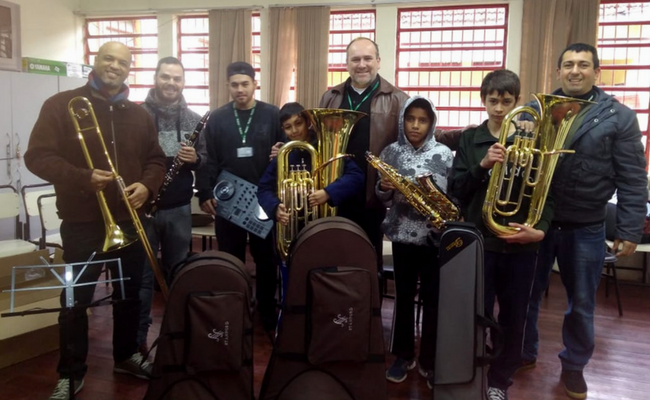 Cinco pessoas em pé segurando instrumentos musicais