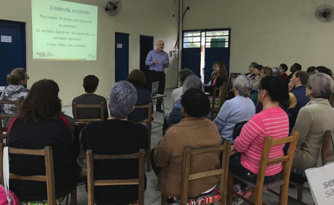 Dr. Antônio Fagan ao fundo em pé e integrantes do PMI sentados