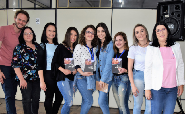 Um homem e oito mulheres em pé, lado a lado