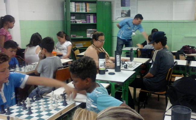 Crianças jogando xadrez em um sala