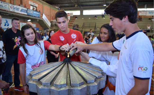 Quatro alunos acendem a pira olímpica