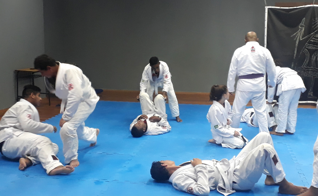 Em um tatame, jovens praticam Jiu-Jitsu