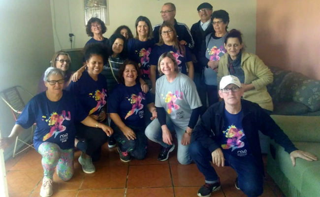 Grupo de pessoas posando para a foto com uma camisa azul, do PMI