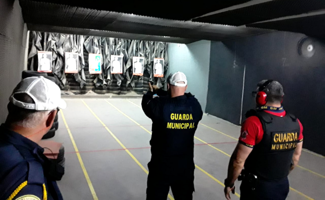 Em um estande de tiro, agente da guarda atirando