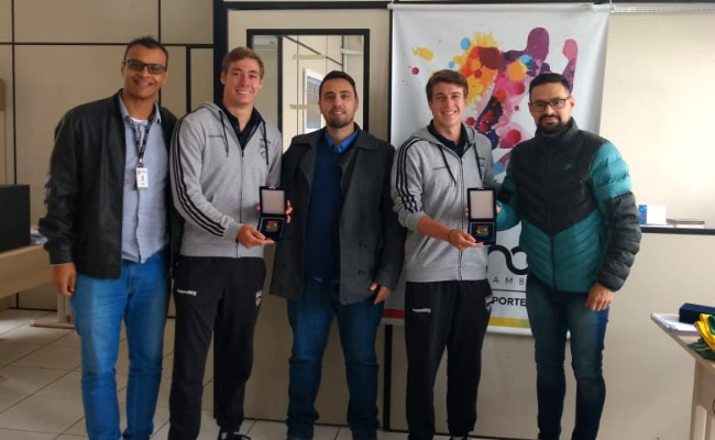 Cinco homens lado a lado em pé