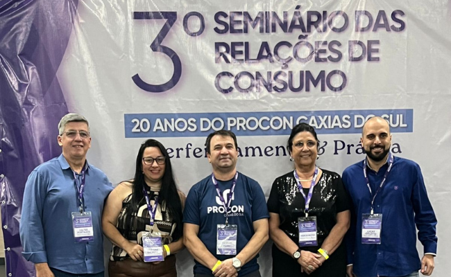 Servidores postados para a foto em frente ao banner do evento