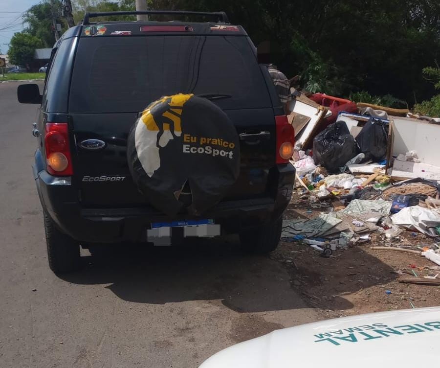 Veículo do infrator ao lado de um descarte irregular de lixo, colocado junto à Avenida da Integração Leopoldo Petry