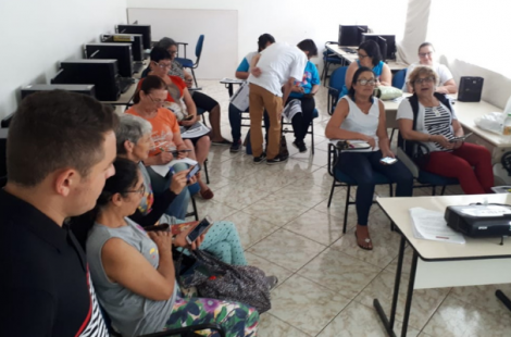 Em uma sala, sentados em cadeiras em formato de l, os alunos do curso